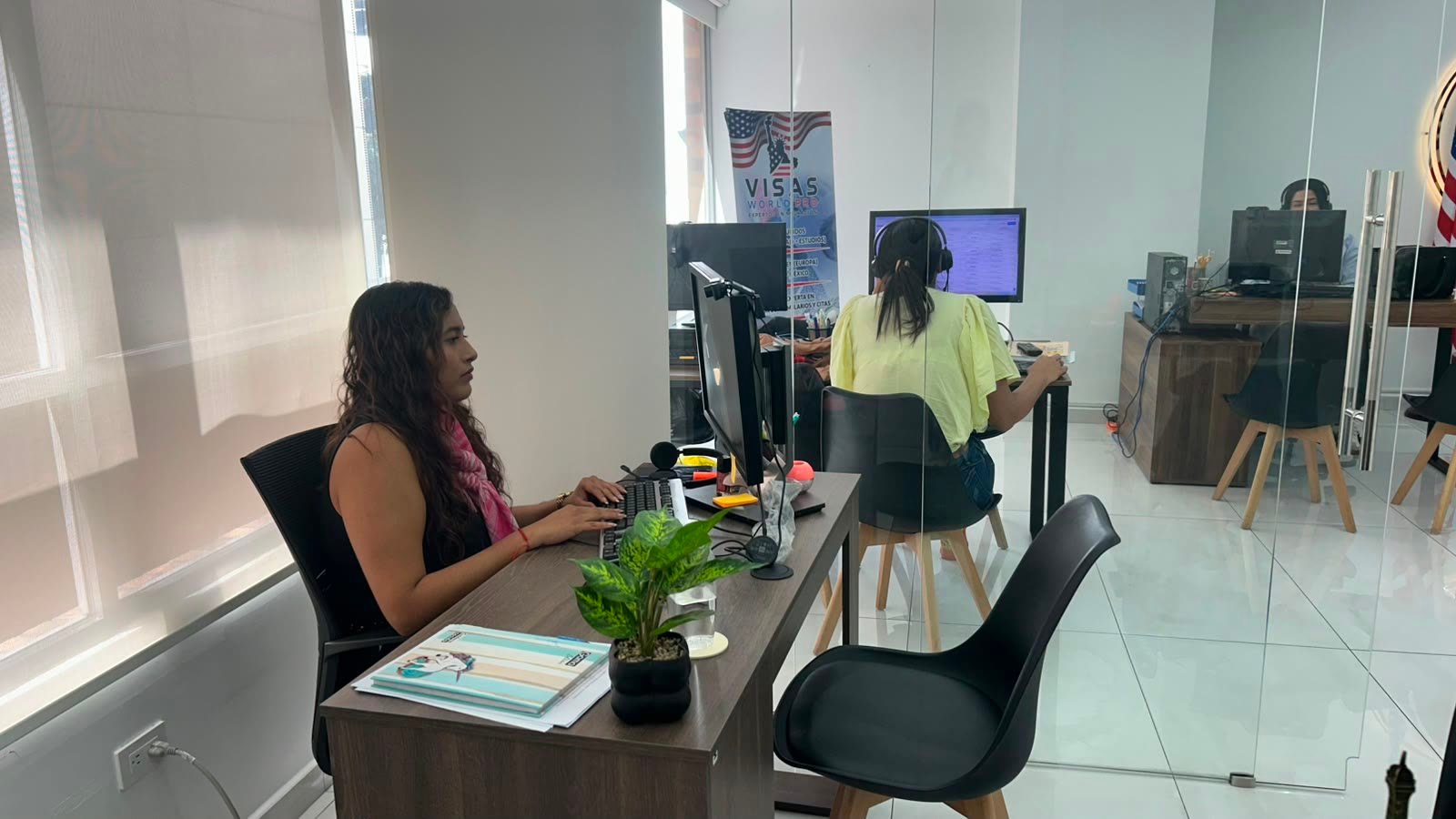 Asesora de Visas World Pro atendiendo en su escritorio dentro de la oficina