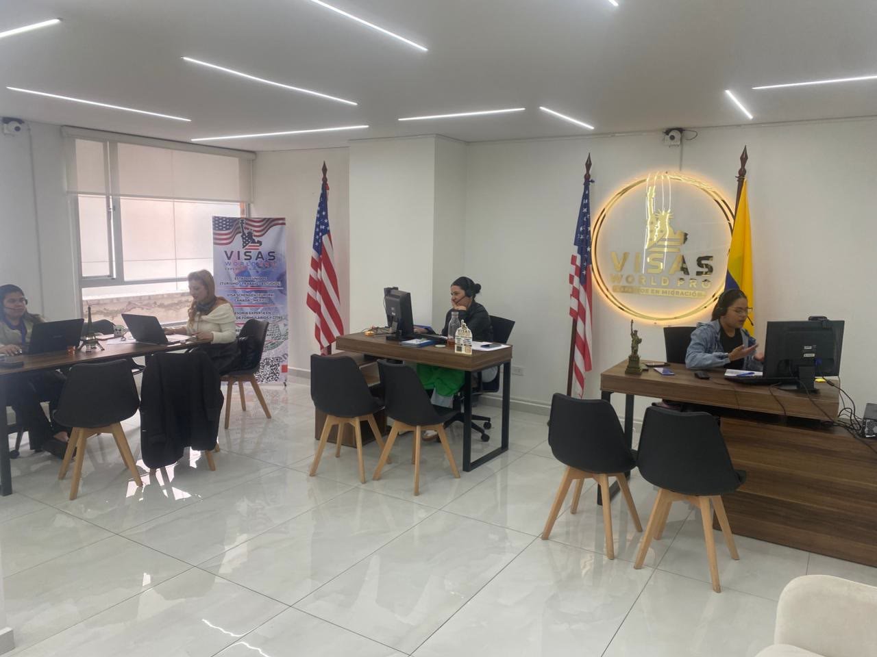 Oficina de Visas World Pro en Quito, con el equipo trabajando y el letrero dorado de la marca en la pared